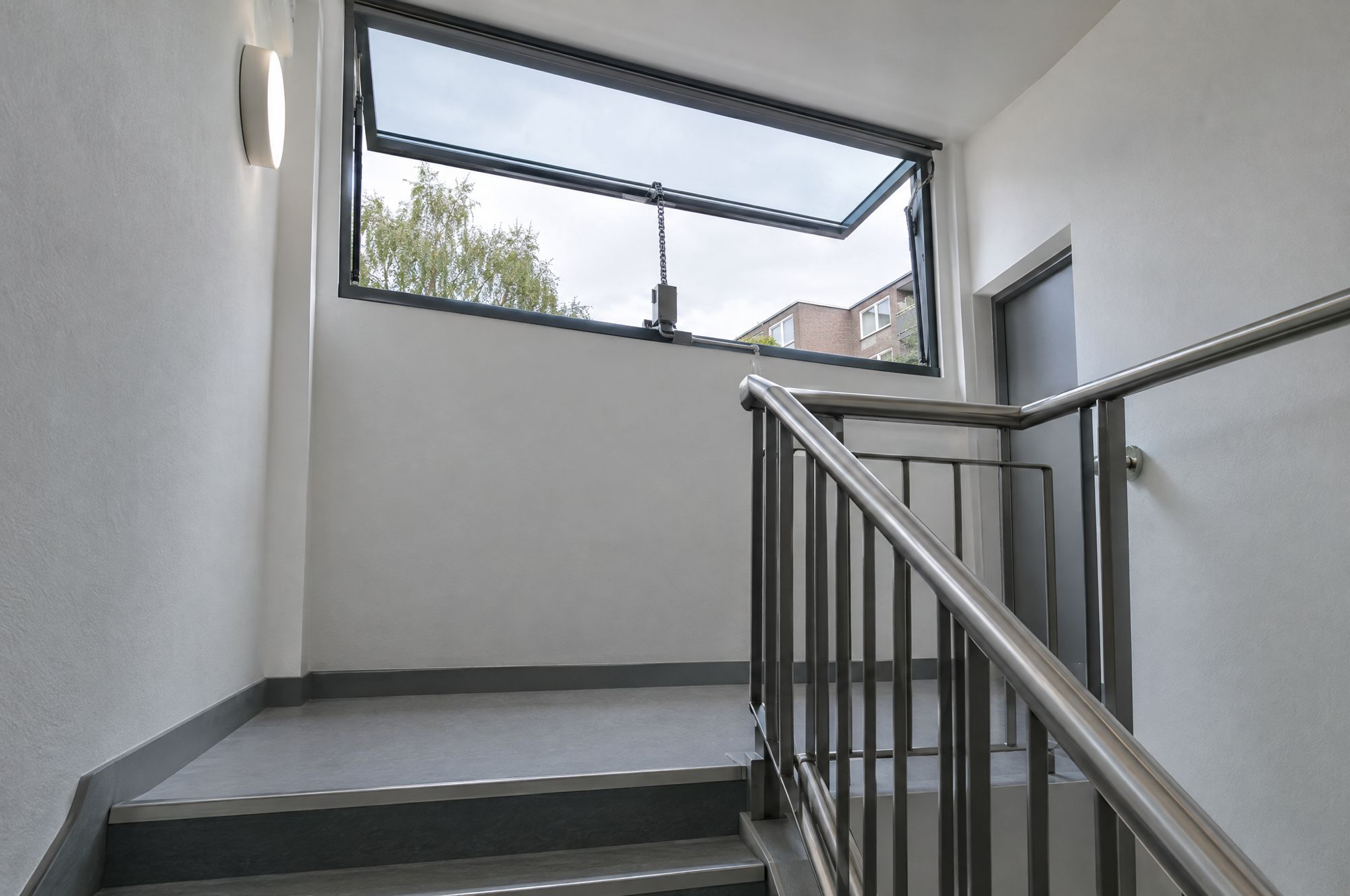 Automatic opening vent at the head of a stairwell