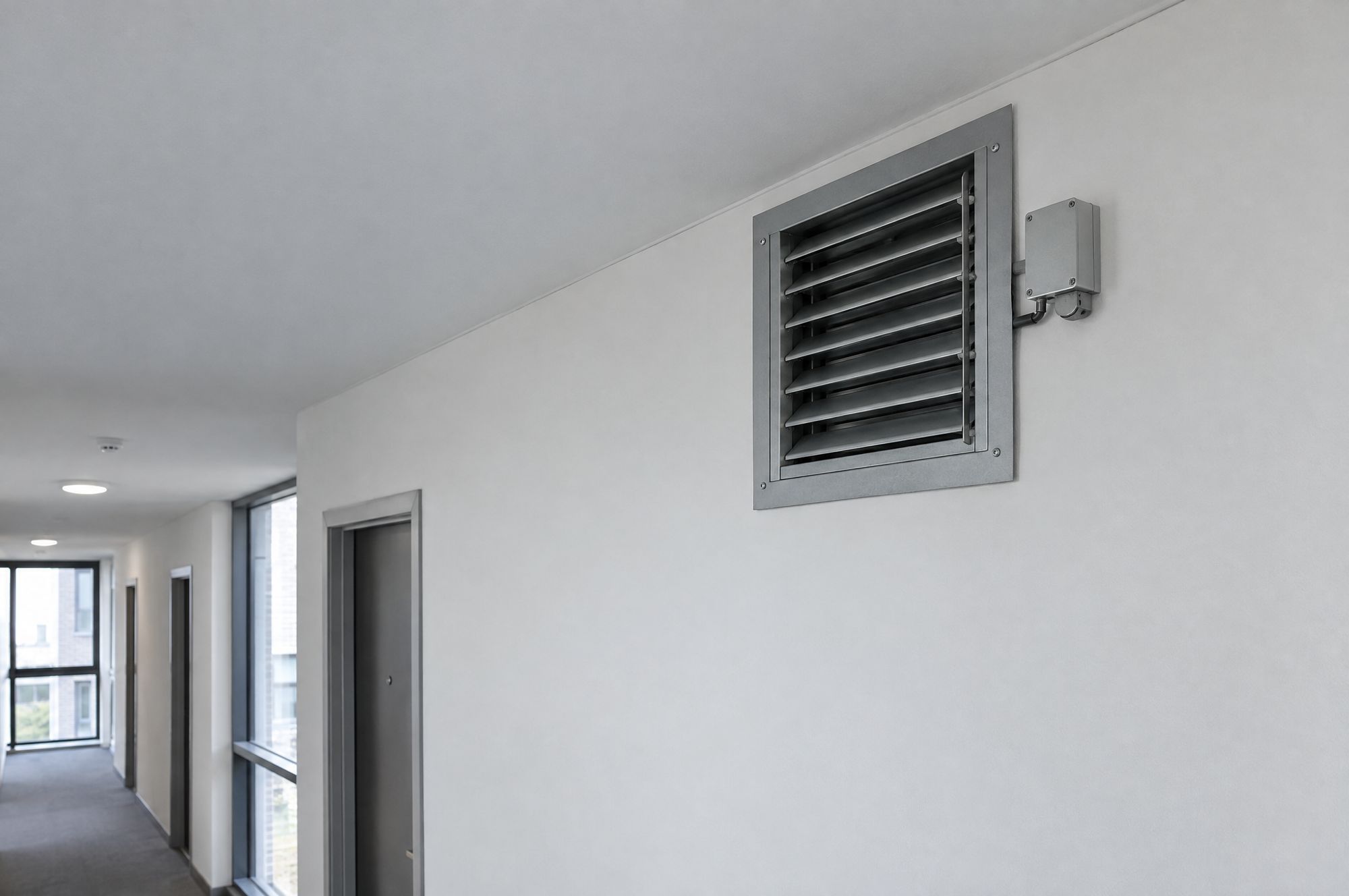 Smoke damper grille set into a corridor wall